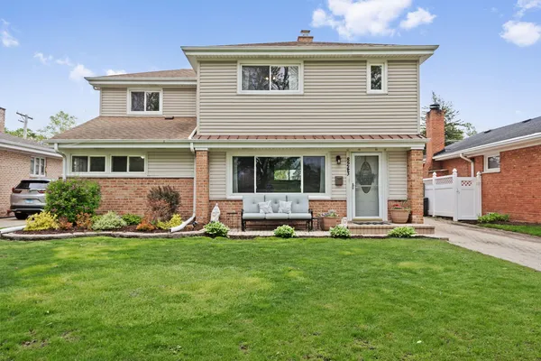 a front view of a house with a yard and many windows