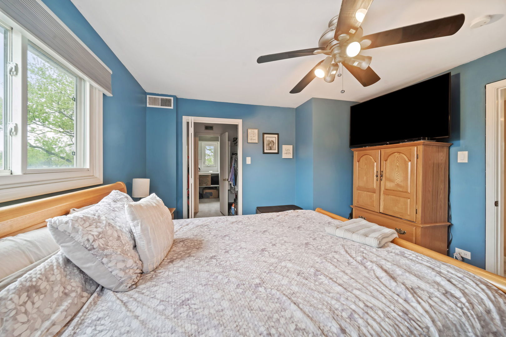 8243 Washington Street Niles, IL 60714 - Photo 16 of 30 a bedroom with a large bed and a flat tv screen