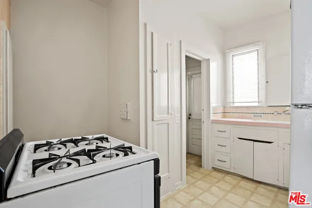 a kitchen with white cabinets and appliances