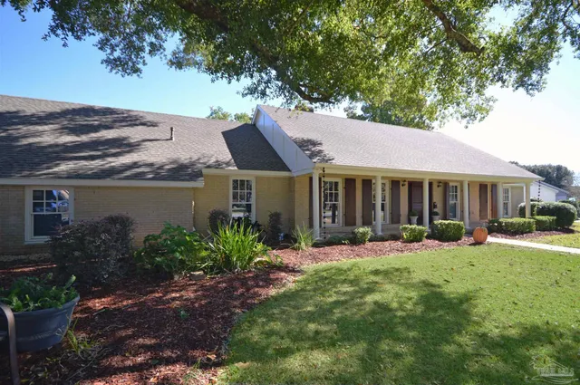 a front view of a house with a garden and yard