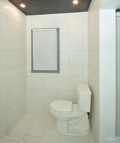 a white toilet sitting next to a white walls