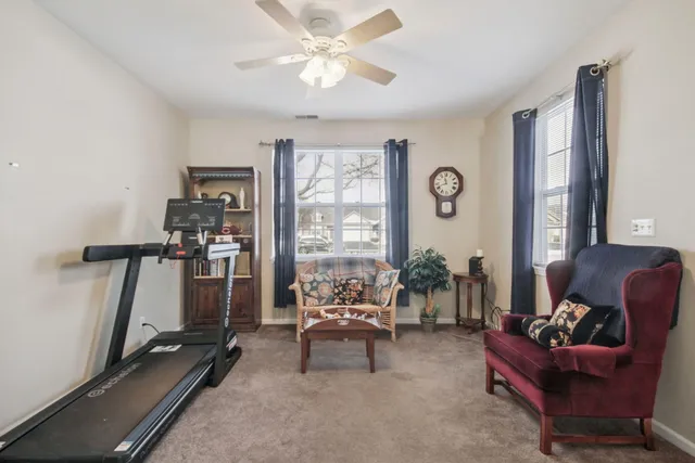 a living room with furniture gym equipment and a large window