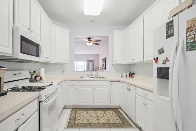 a kitchen with cabinets appliances a sink and a counter top