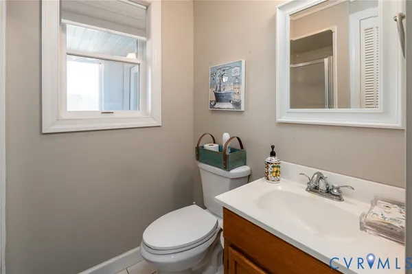 a bathroom with a toilet sink vanity and mirror