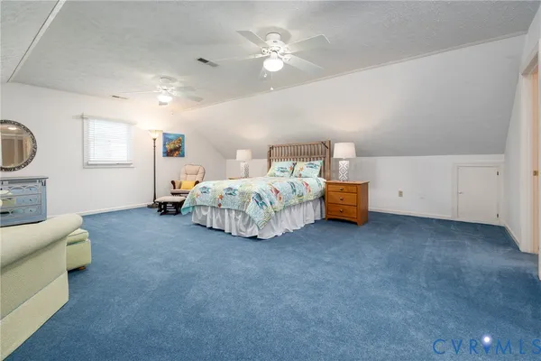 a spacious bedroom with a bed and a chandelier