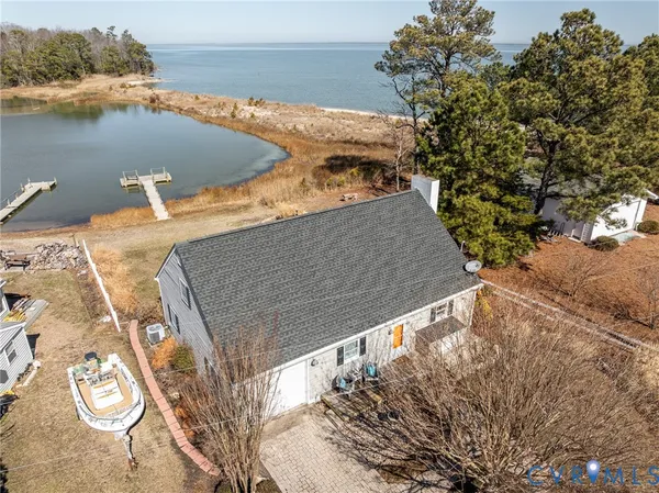 an aerial view of a house with a yard and ocean view