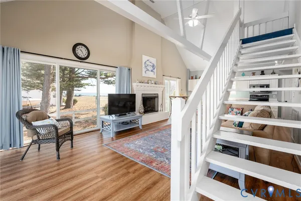 a living room with furniture wooden floor and a floor to ceiling window