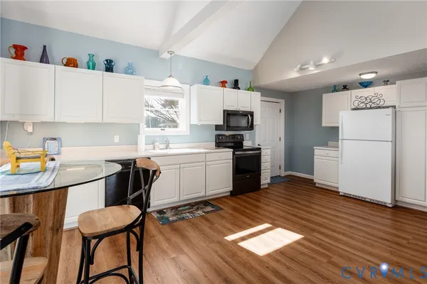 a kitchen with granite countertop appliances a sink and a refrigerator