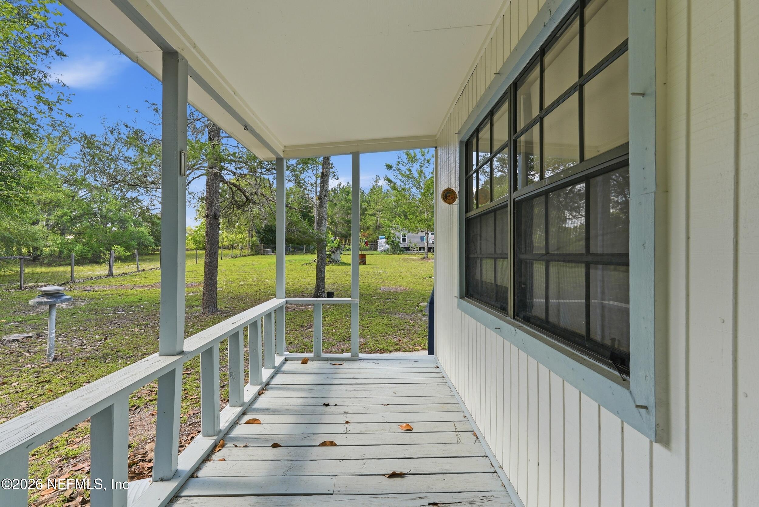 7593 Silver Sands Road Keystone Heights, FL 32656 - Photo 25 of 36 a view of balcony with wooden floor and fence