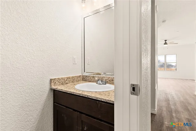 a bathroom with a granite countertop sink and a mirror
