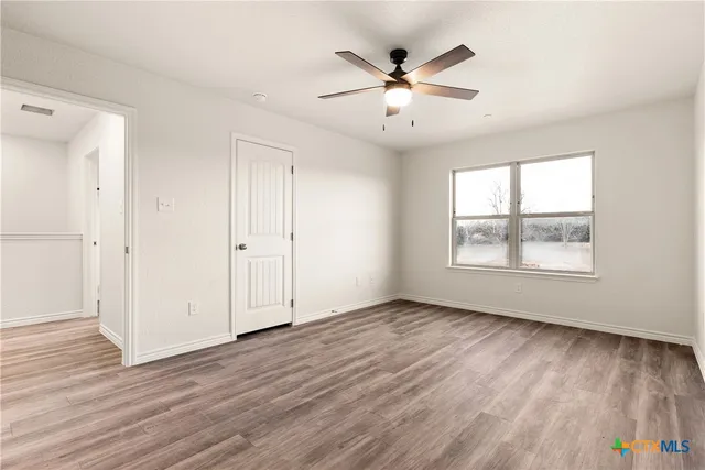 a view of empty room with wooden floor