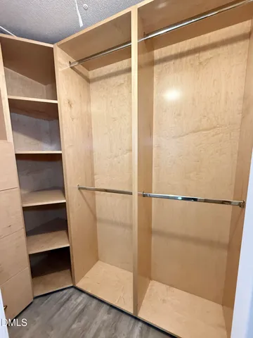 a view of walk in closet with empty racks