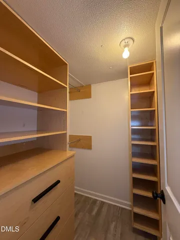 a view of walk in closet with empty racks