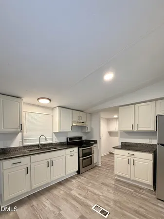 a large kitchen with stainless steel appliances granite countertop a stove and a sink