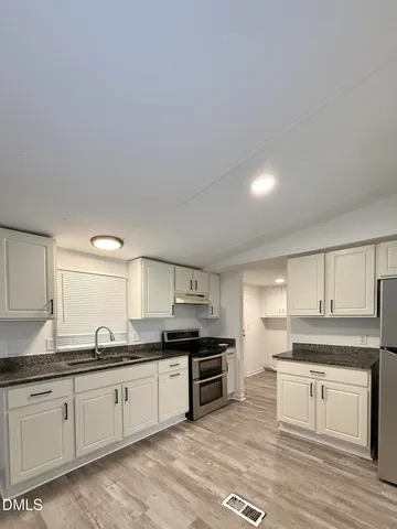 a large kitchen with stainless steel appliances granite countertop a stove and a sink