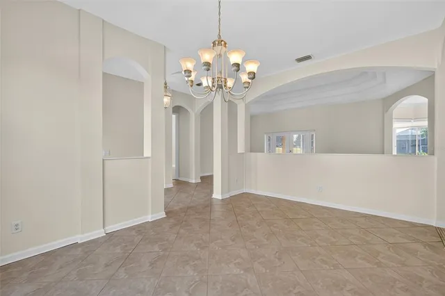 a view of an empty room with chandelier