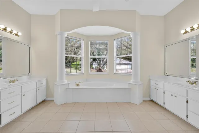 a spacious bathroom with a tub sink and mirror