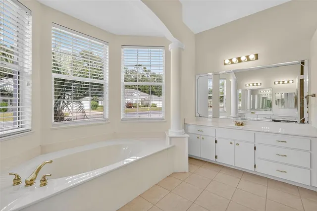 a spacious bathroom with a tub sink and mirror