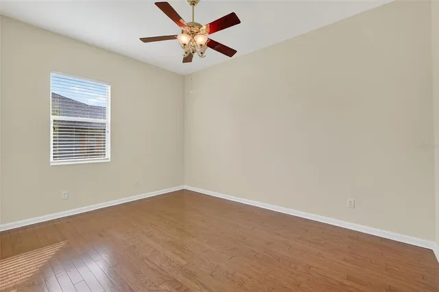 an empty room with a window and a fan