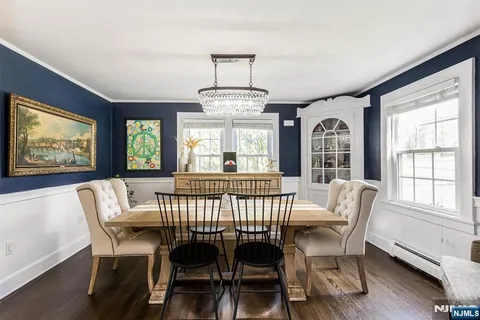 a view of a dining room with furniture a chandelier and wooden floor