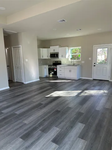 a view of empty room with wooden floor