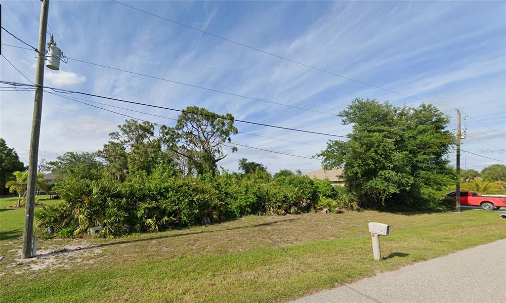 146 Indigo Road Rotonda West, FL 33947 - Photo 4 of 8 a street view with tall trees
