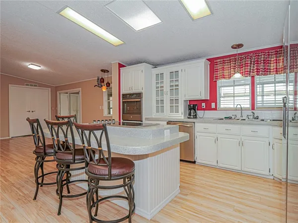 a kitchen with stainless steel appliances a dining table chairs microwave and sink