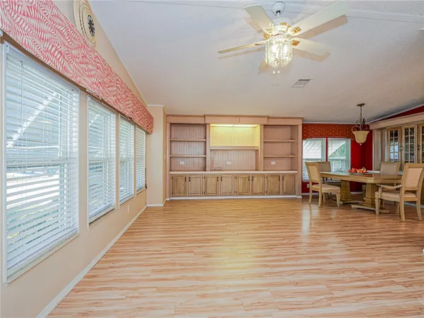 a dining room with wooden floor a glass table and chairs
