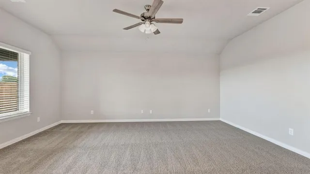 an empty room with a window and a fan