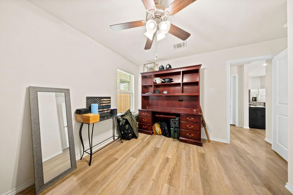 822 Ramble Road Lavon, TX 75166 - Photo 19 of 35 Spacious room featuring wood-finish flooring, light neutral wall paint, and a ceiling fan with integrated lighting