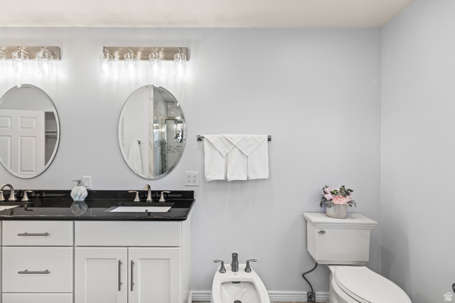 460 Omni Point Road Central Valley, UT 84754 - Photo 42 of 101 Dual vanity with white cabinetry, dark stone countertops, and undermount sinks
