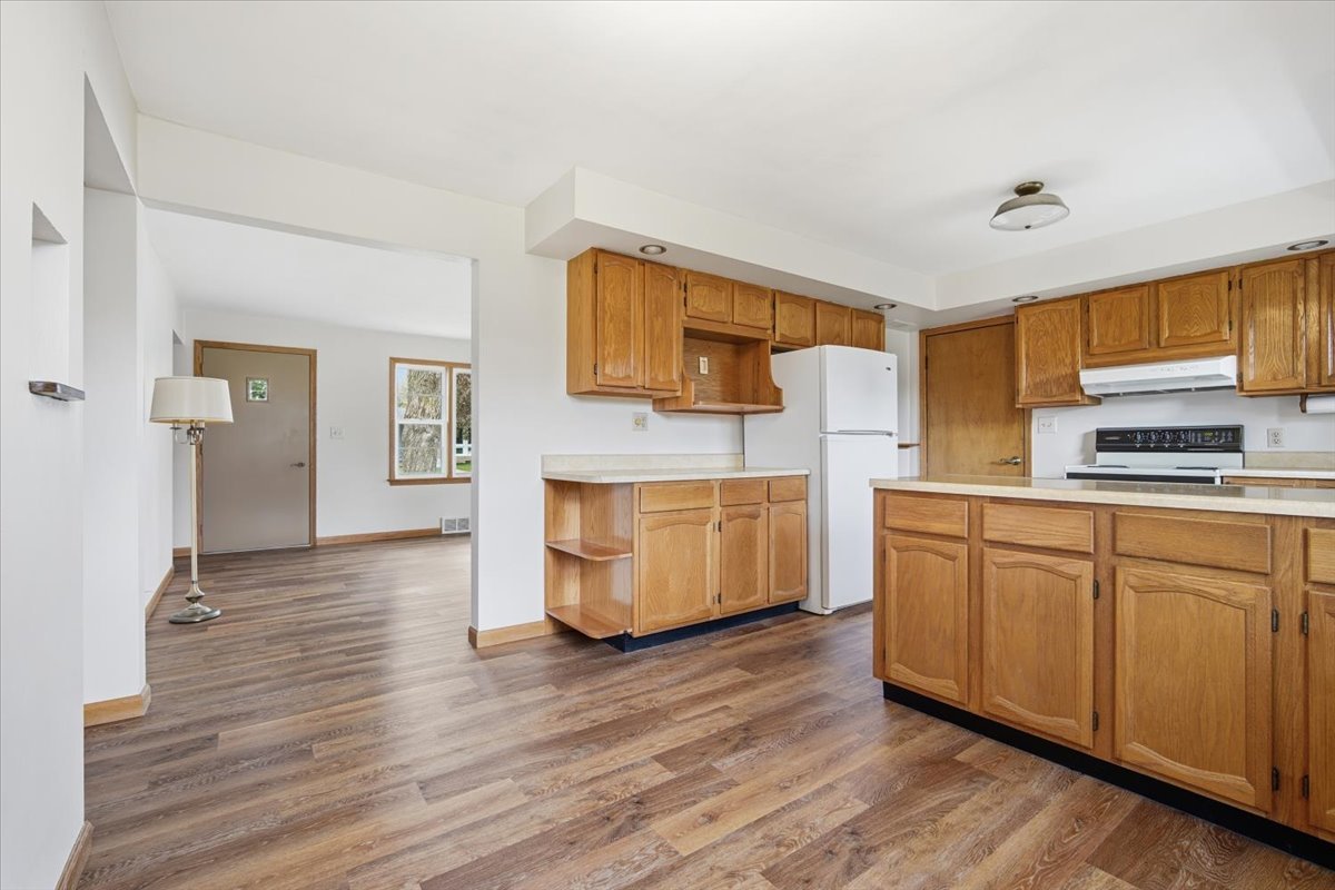 509 Smith Street Roanoke, IL 61561 - Photo 9 of 28 a kitchen with granite countertop wooden floors and white stainless steel appliances