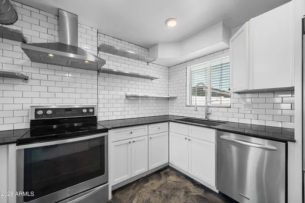 a kitchen with stainless steel appliances a stove sink and cabinets