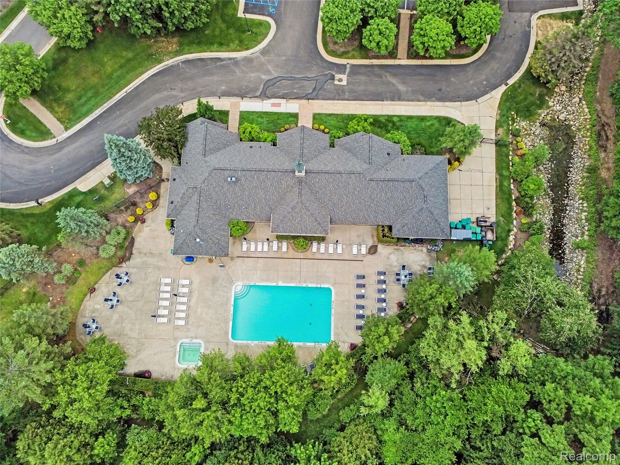 3633 Oakmonte Boulevard, Unit 189 Rochester, MI 48306 - Photo 5 of 36 Recreational building featuring a rectangular swimming pool, integrated spa, and expansive paved patio