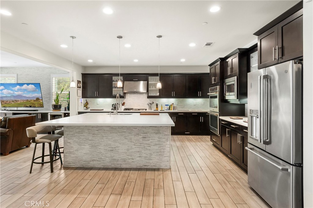 12528 Locke Circle Riverside, CA 92503 - Photo 2 of 46 a large kitchen with stainless steel appliances granite countertop a stove top oven a refrigerator a sink and a dining table with wooden floor
