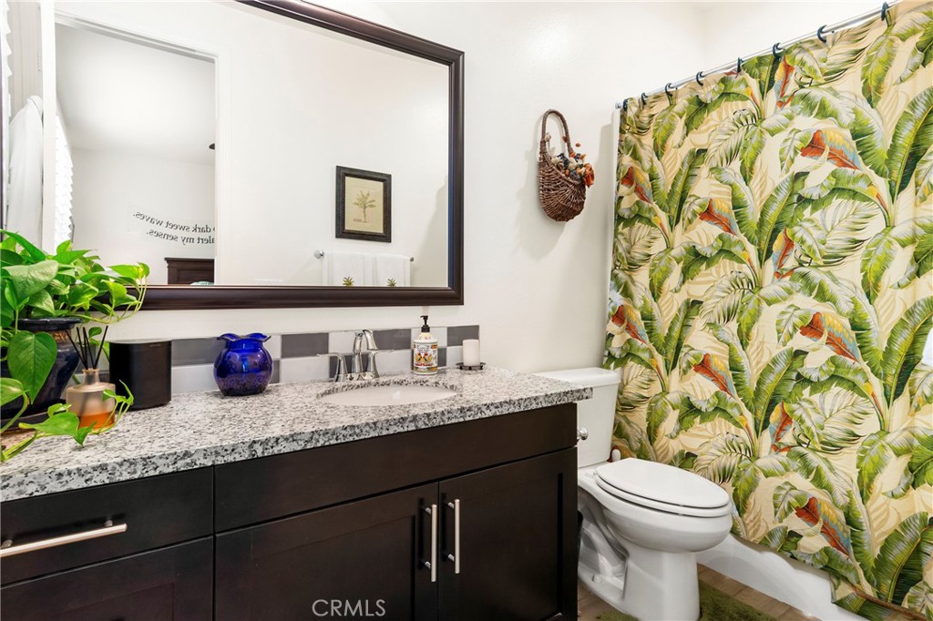 12528 Locke Circle Riverside, CA 92503 - Photo 27 of 46 a bathroom with a granite countertop sink a toilet and mirror