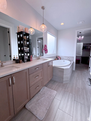 429 East Treasure Road Washington, UT 84780 - Photo 25 of 36 Full bath featuring double vanity, a garden tub, and suspended lighting