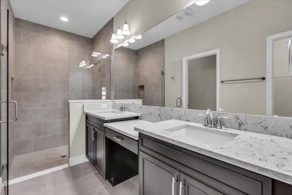a bathroom with a granite countertop sink a large mirror and a shower