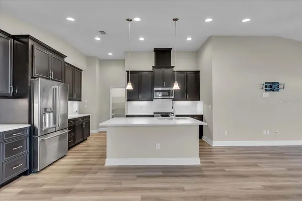 a kitchen with stainless steel appliances a refrigerator and a stove top oven