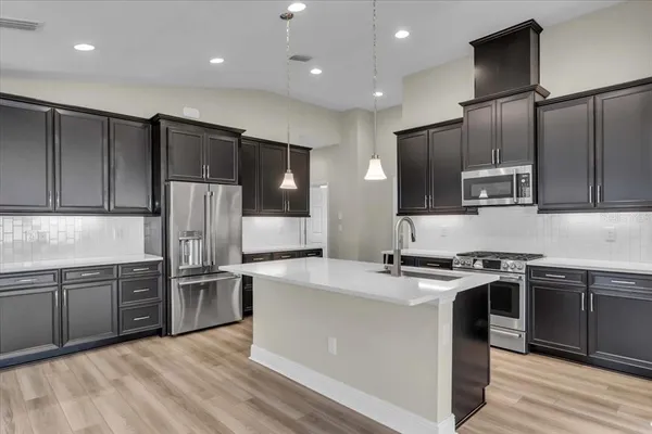 a kitchen with stainless steel appliances granite countertop a sink stove and refrigerator
