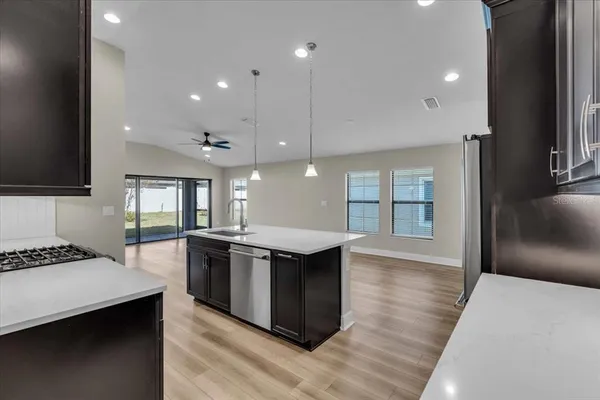 a kitchen with stainless steel appliances granite countertop a sink stove and cabinets
