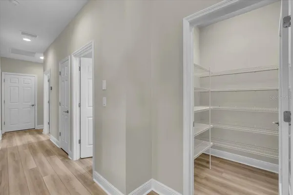 a view of walk in closet with empty racks