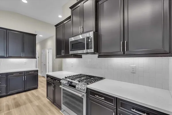 a kitchen with stainless steel appliances granite countertop a sink and a stove