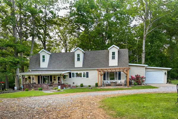 a front view of a house with a yard and trees