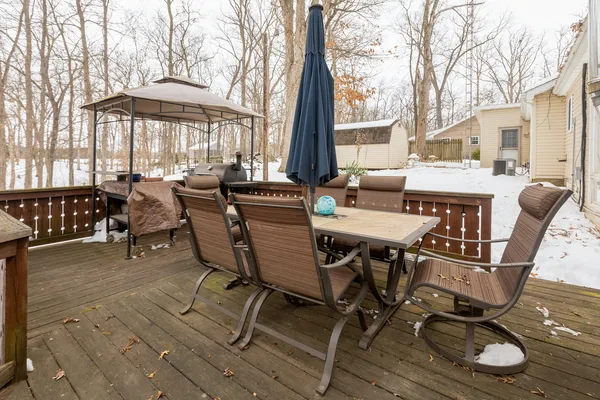 a view of a patio with table and chairs with wooden floor and floor to ceiling window