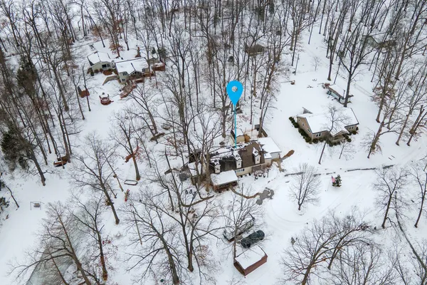 a front view of a house with a yard covered in snow