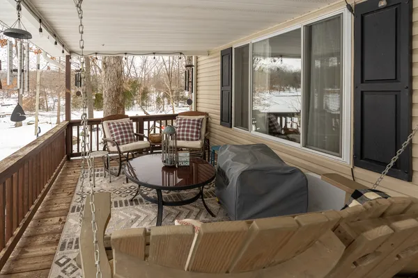 a living room with furniture a flat screen tv and kitchen view