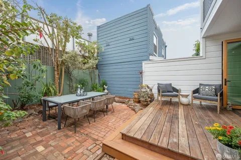 a view of a patio with table and chairs potted plants and a wooden deck