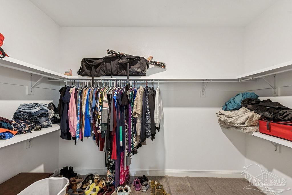 1555 Cadence Loop Cantonment, FL 32533 - Photo 19 of 34 a view of walk in closet with clothes and shoes