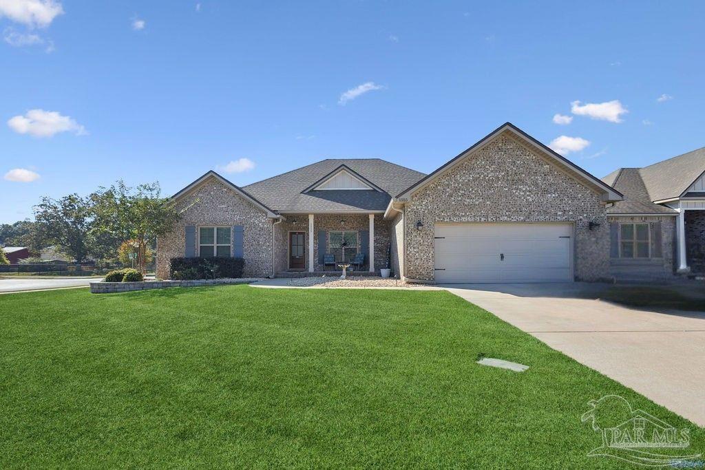 1555 Cadence Loop Cantonment, FL 32533 - Photo 2 of 34 a front view of a house with a garden and porch